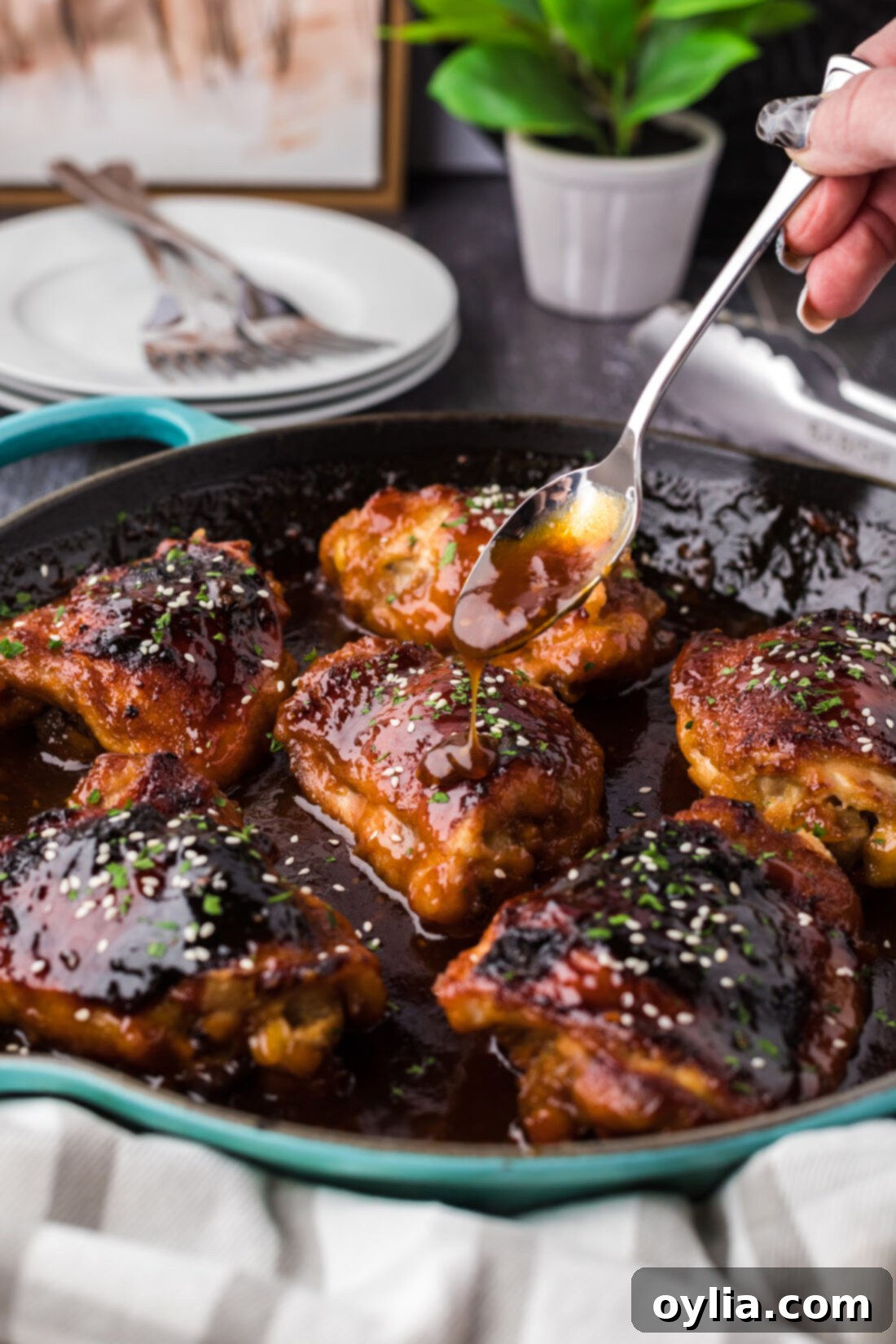 Honey Garlic Chicken in a skillet with sauce being drizzled over the chicken