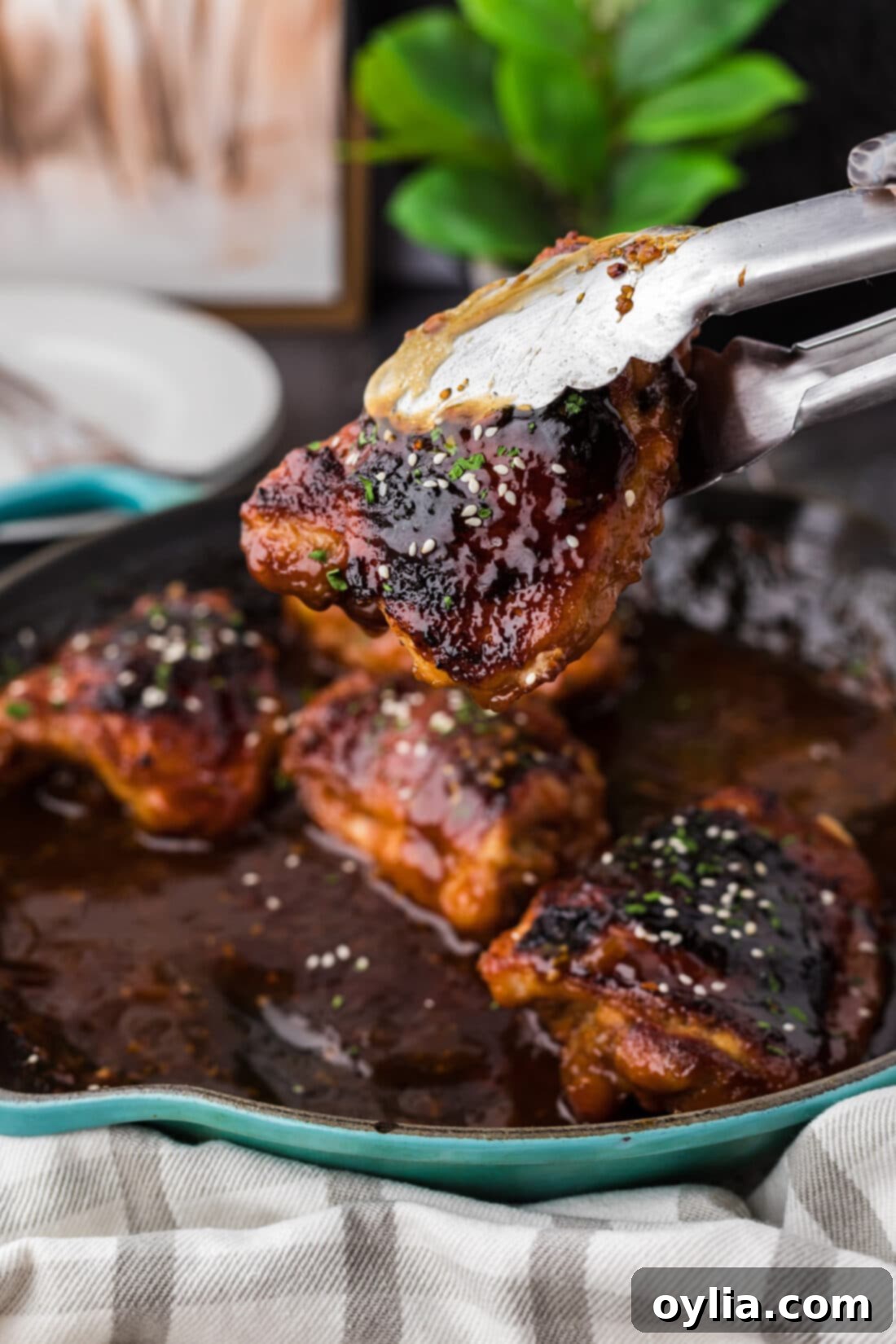 Piece of Honey Garlic Chicken being lifted out of the skillet