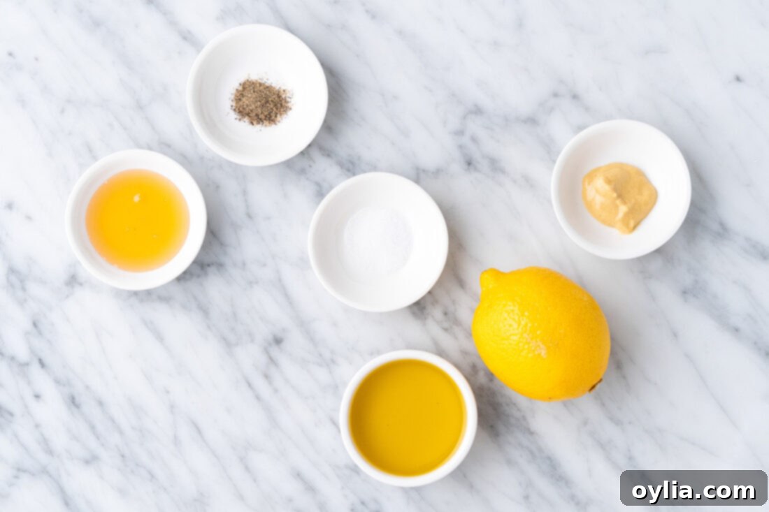 Ingredients for homemade lemon salad dressing: lemon, olive oil, honey, Dijon mustard