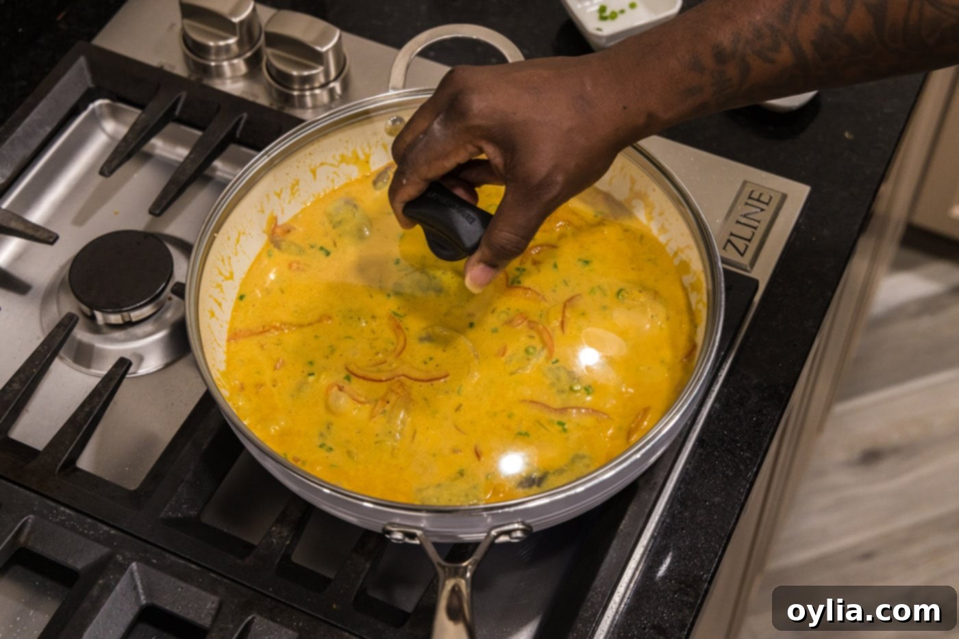 placing a lid on shrimp curry on the stovetop