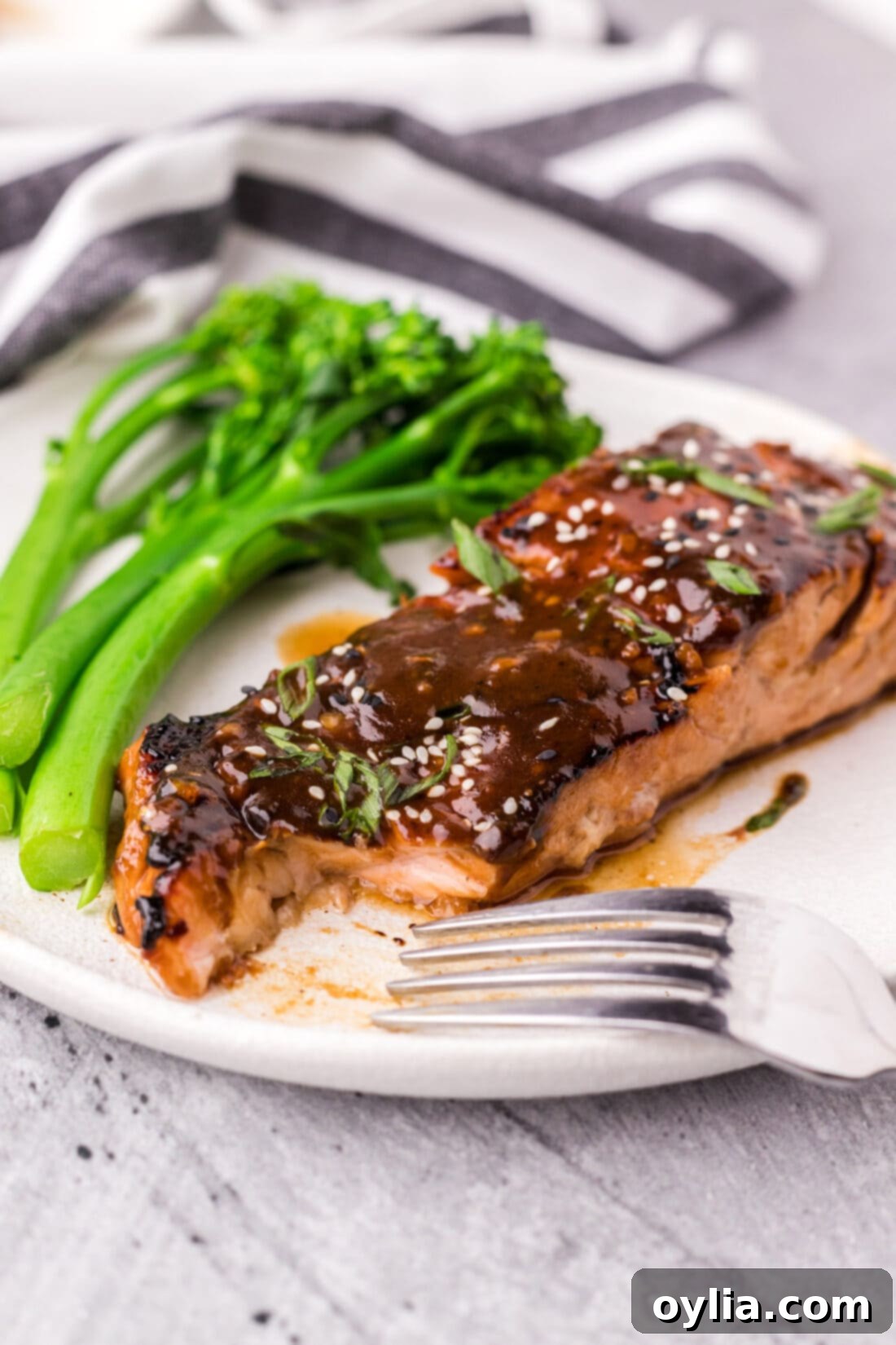 Glazed Teriyaki Salmon 11 Teriyaki Salmon on a plate with a piece taken out, showing the flaky interior