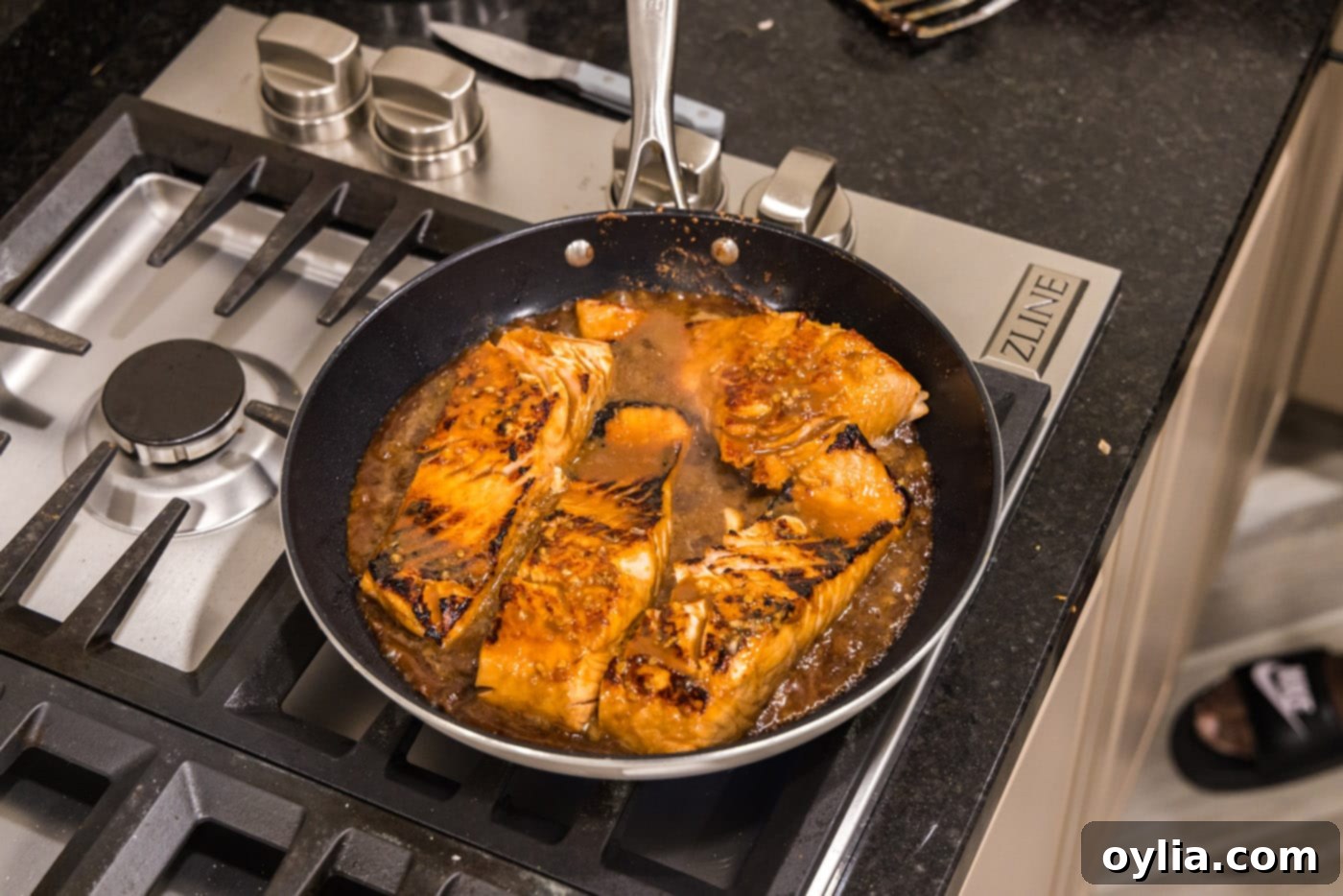 cooked teriyaki salmon in a skillet with the glaze