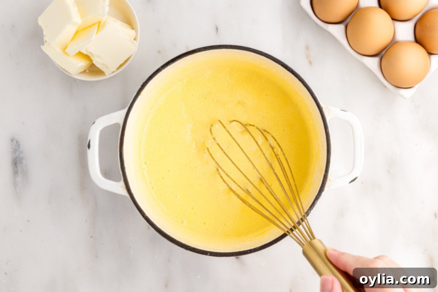 whisking pineapple curd in a saucepan