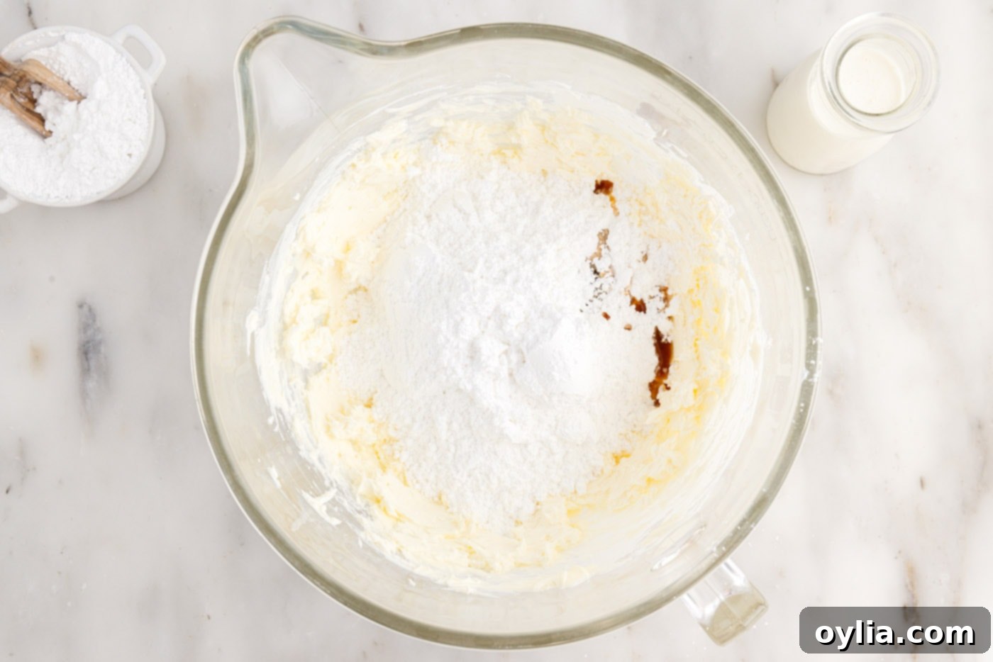 adding powdered sugar and vanilla to cream cheese frosting