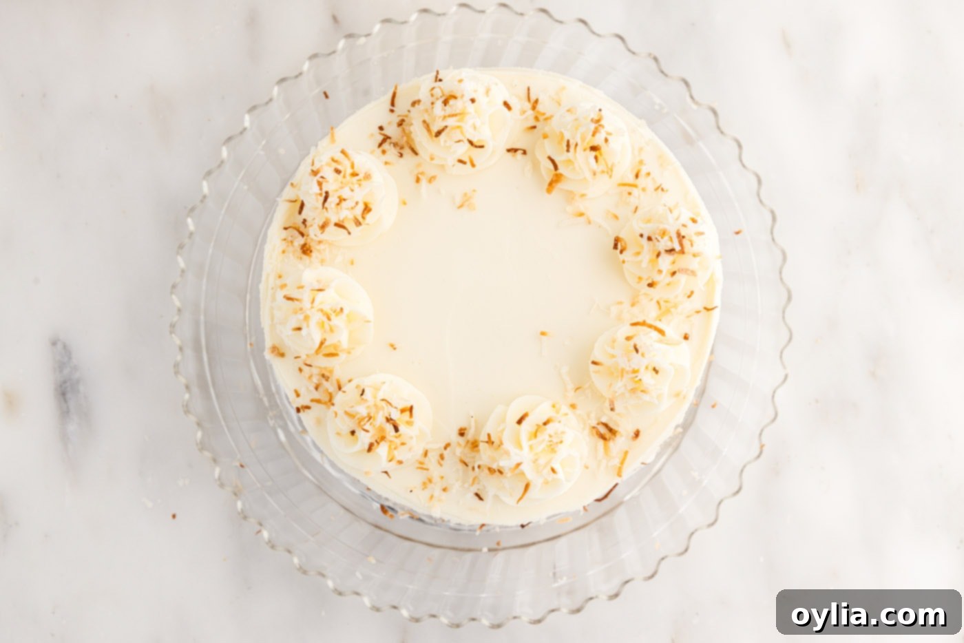 toasted coconut added on top of frosted pineapple coconut cake