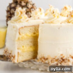 Pineapple Coconut Cake on a cake stand with a slice being removed