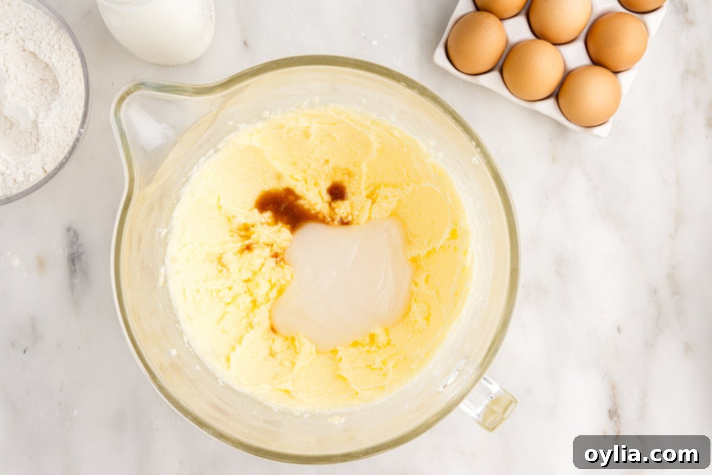 adding vanilla extract, coconut extract, and cream of coconut to cake mixture