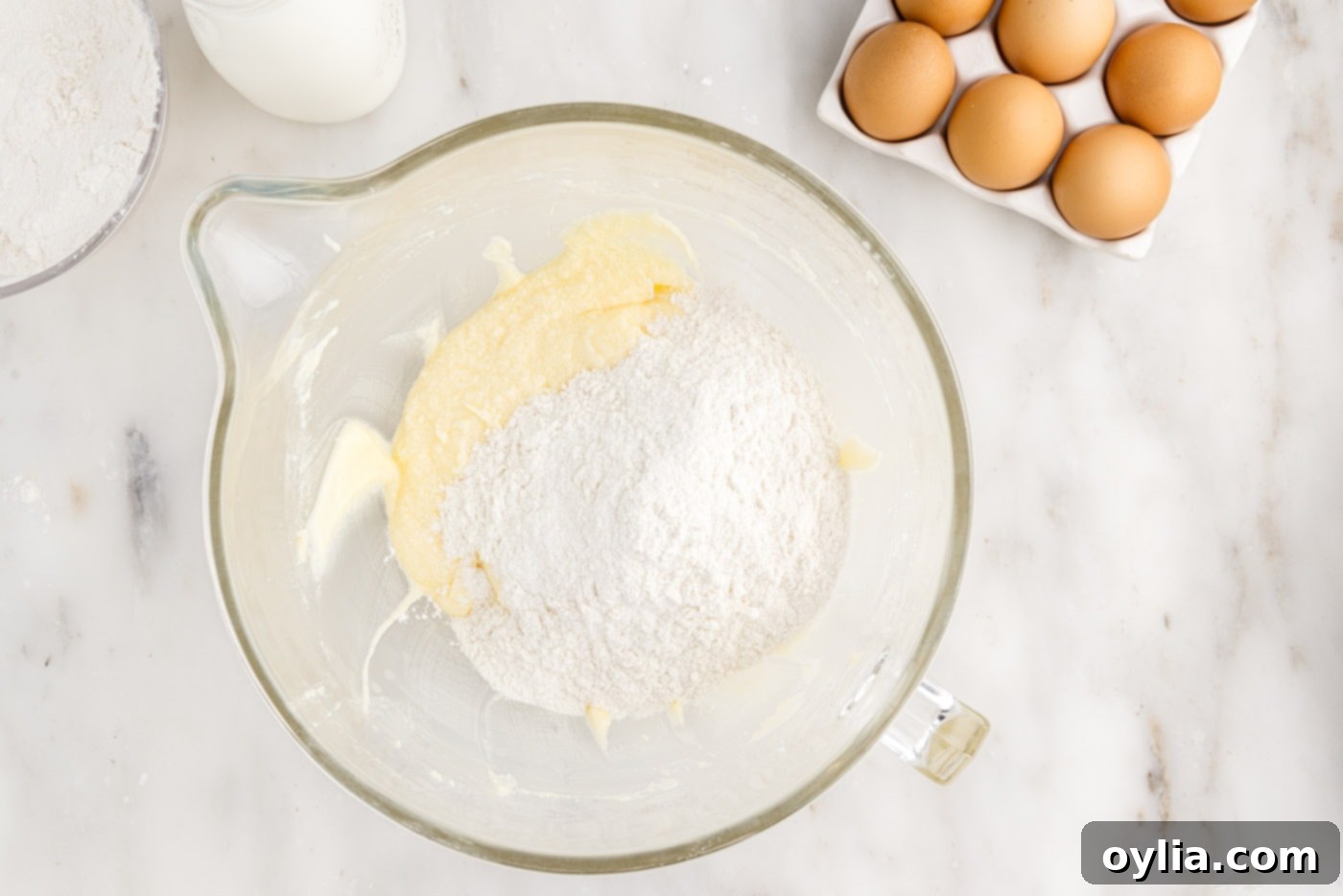 adding dry ingredients to wet ingredients for cake in a bowl