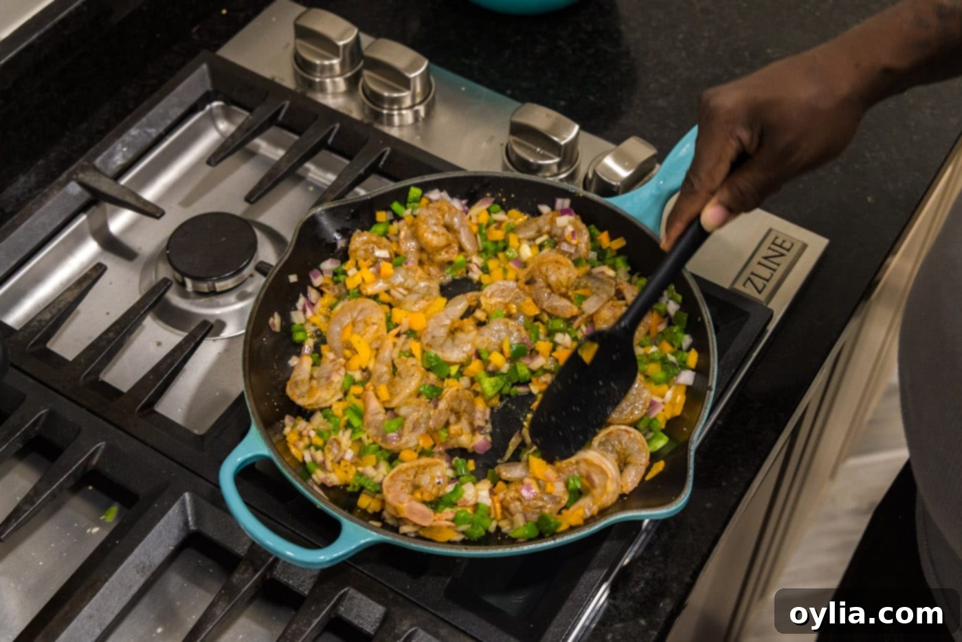 stirring shrimp quesadilla ingredients in a skillet, showing perfectly cooked shrimp and colorful vegetables