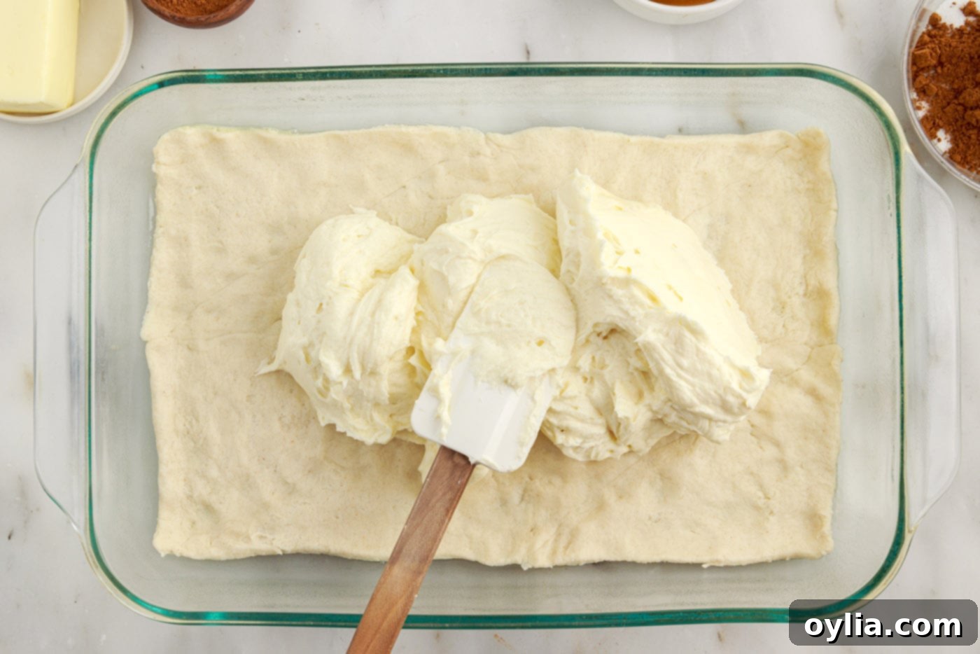 spreading cheesecake over crescent dough