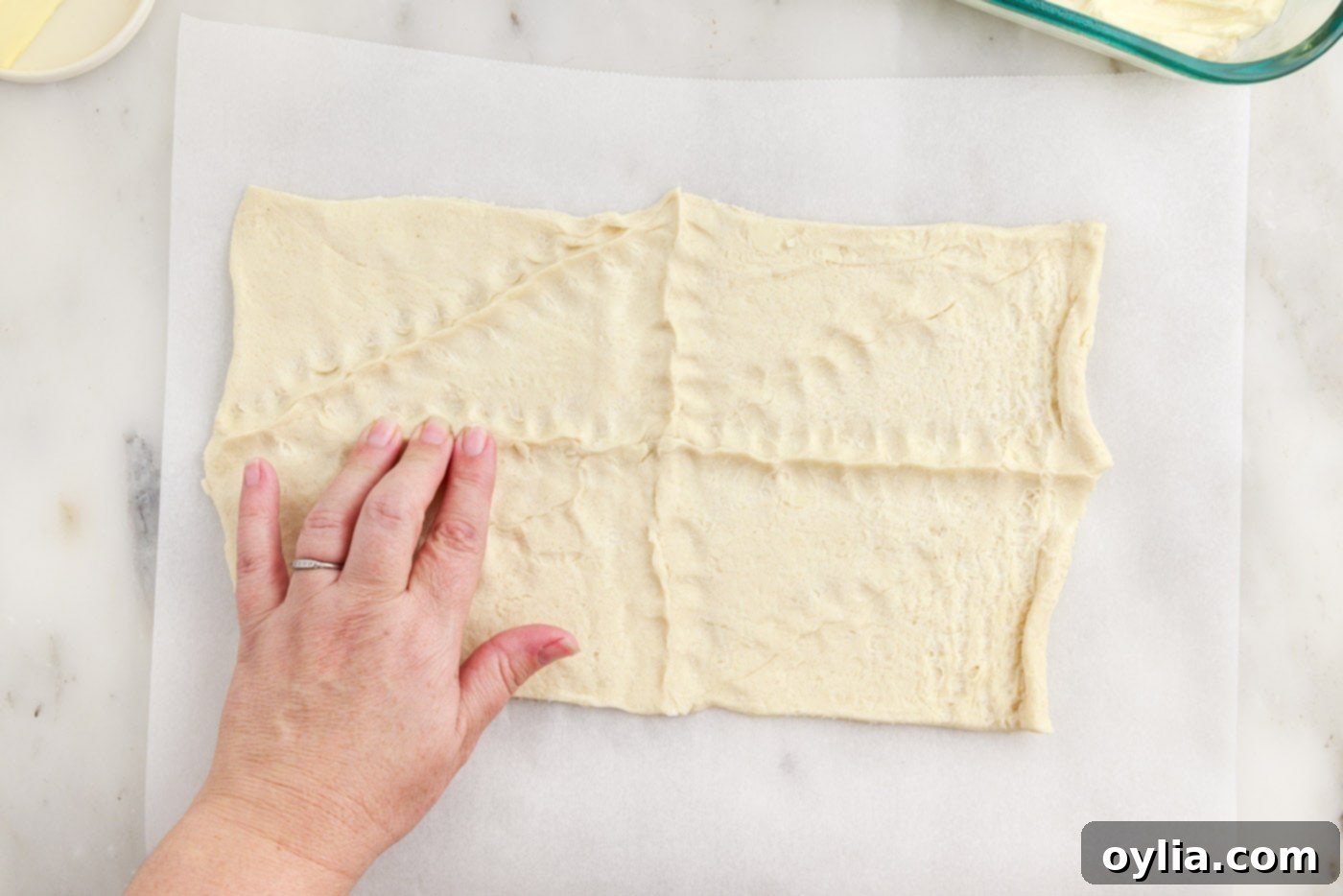 hand pressing the seams of crescent dough together