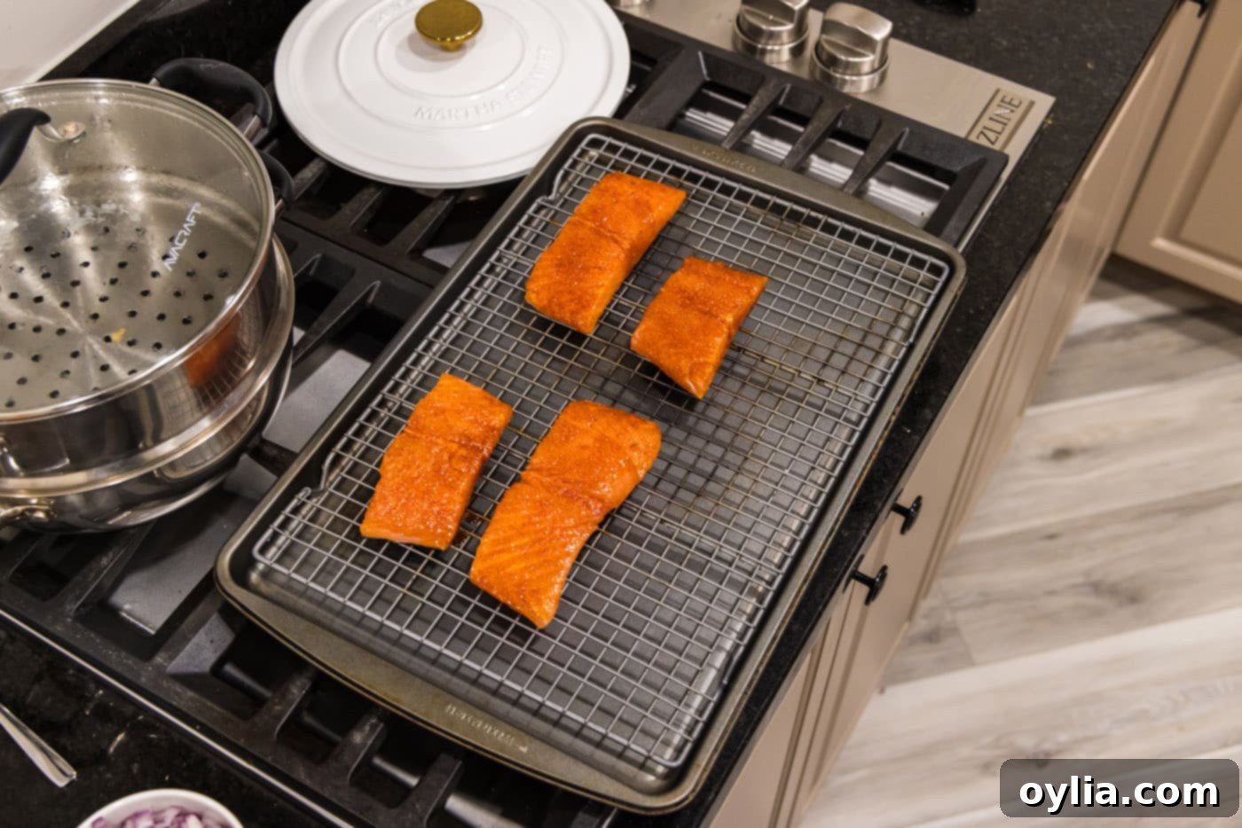 four salmon filets on a wire rack over a baking sheet