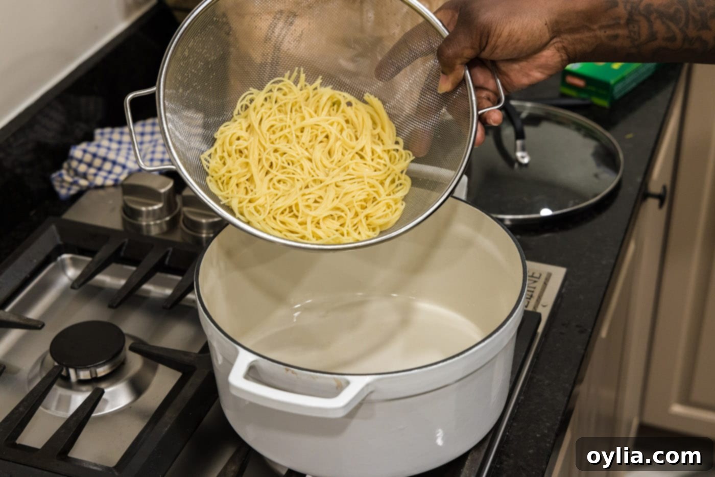 draining pasta in a sieve over a sink