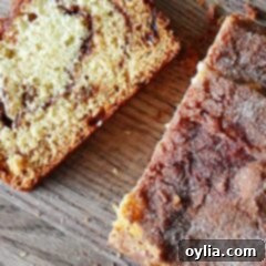 Swirled Cinnamon Raisin Quick Bread 7 A close up photo of a sliced loaf of cinnamon raisin swirl quick bread on a wooden cutting board.