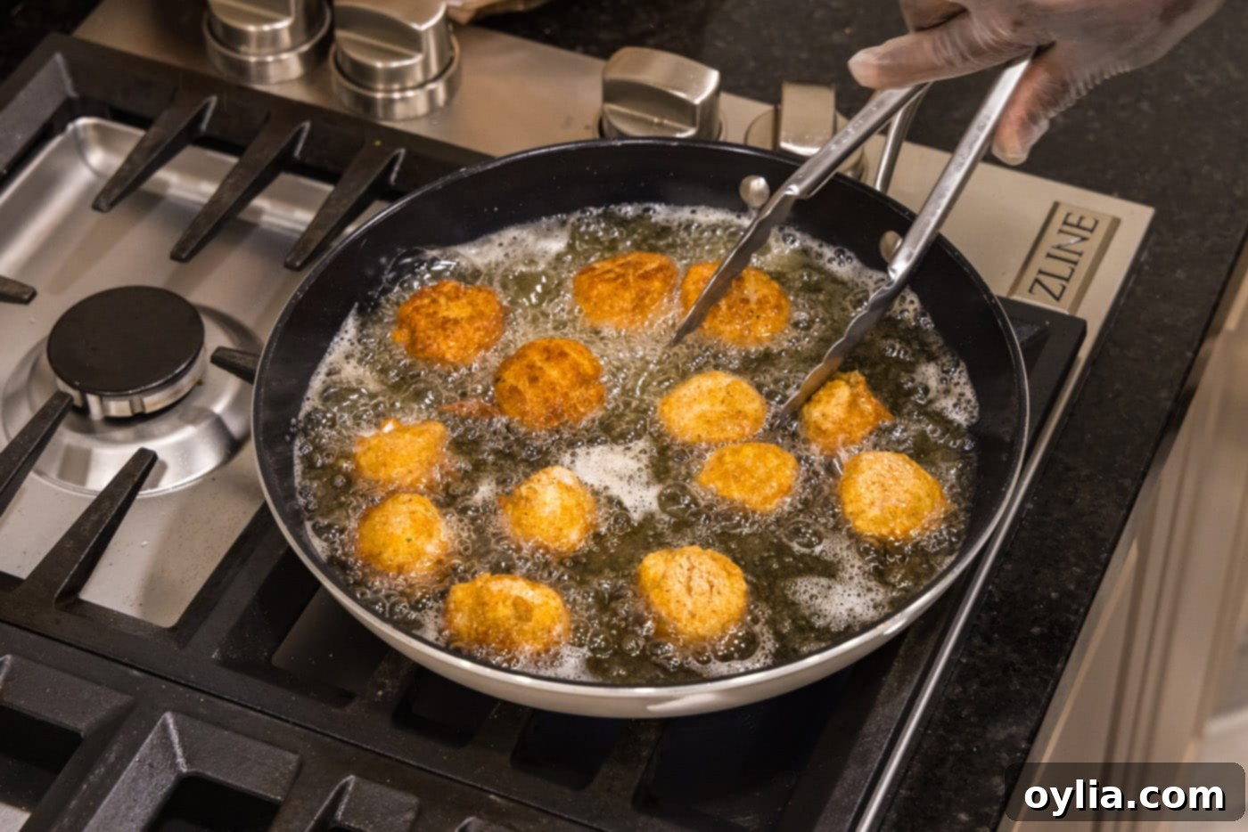 tongs flipping fried scallops in a skillet