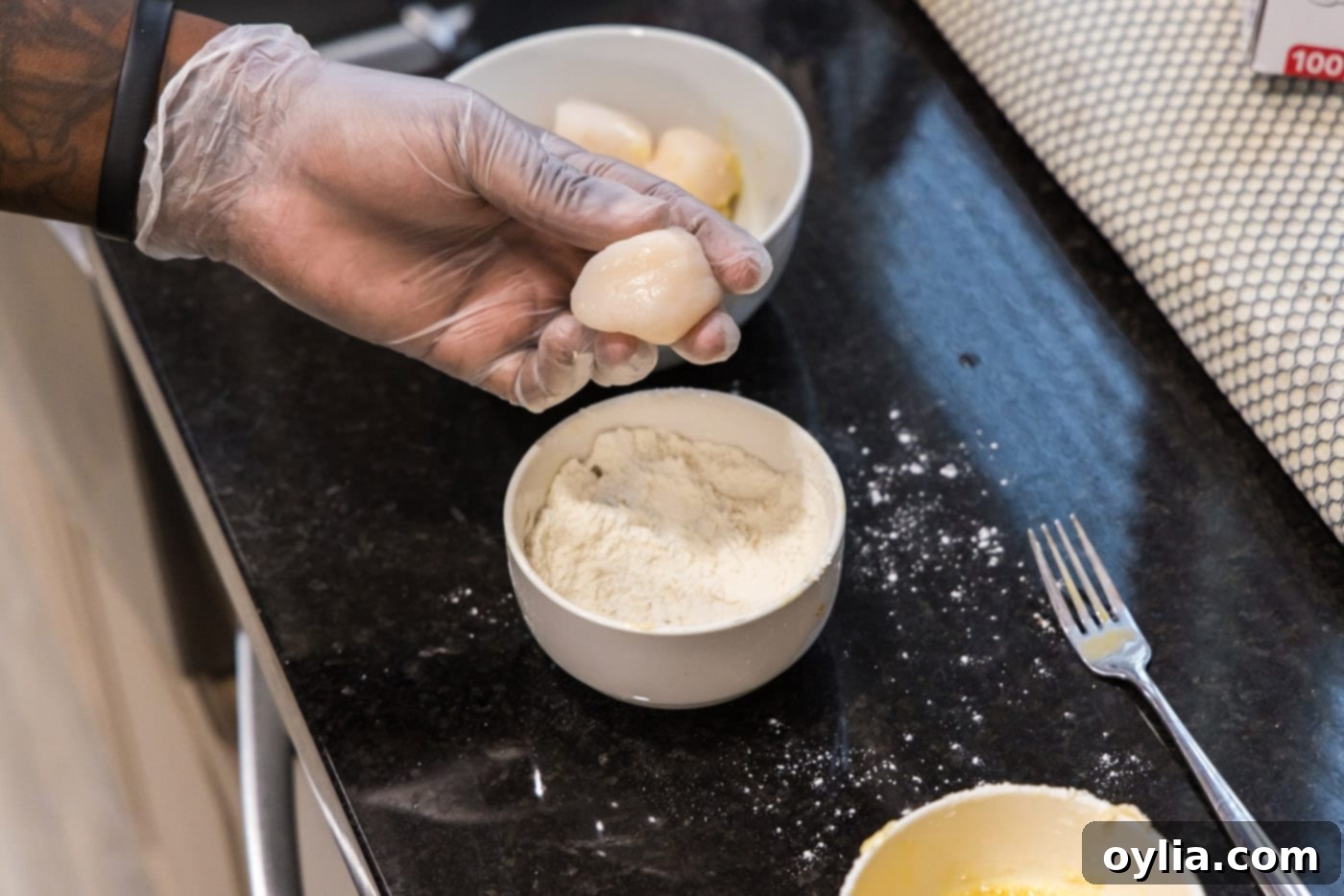 dipping scallop into flour