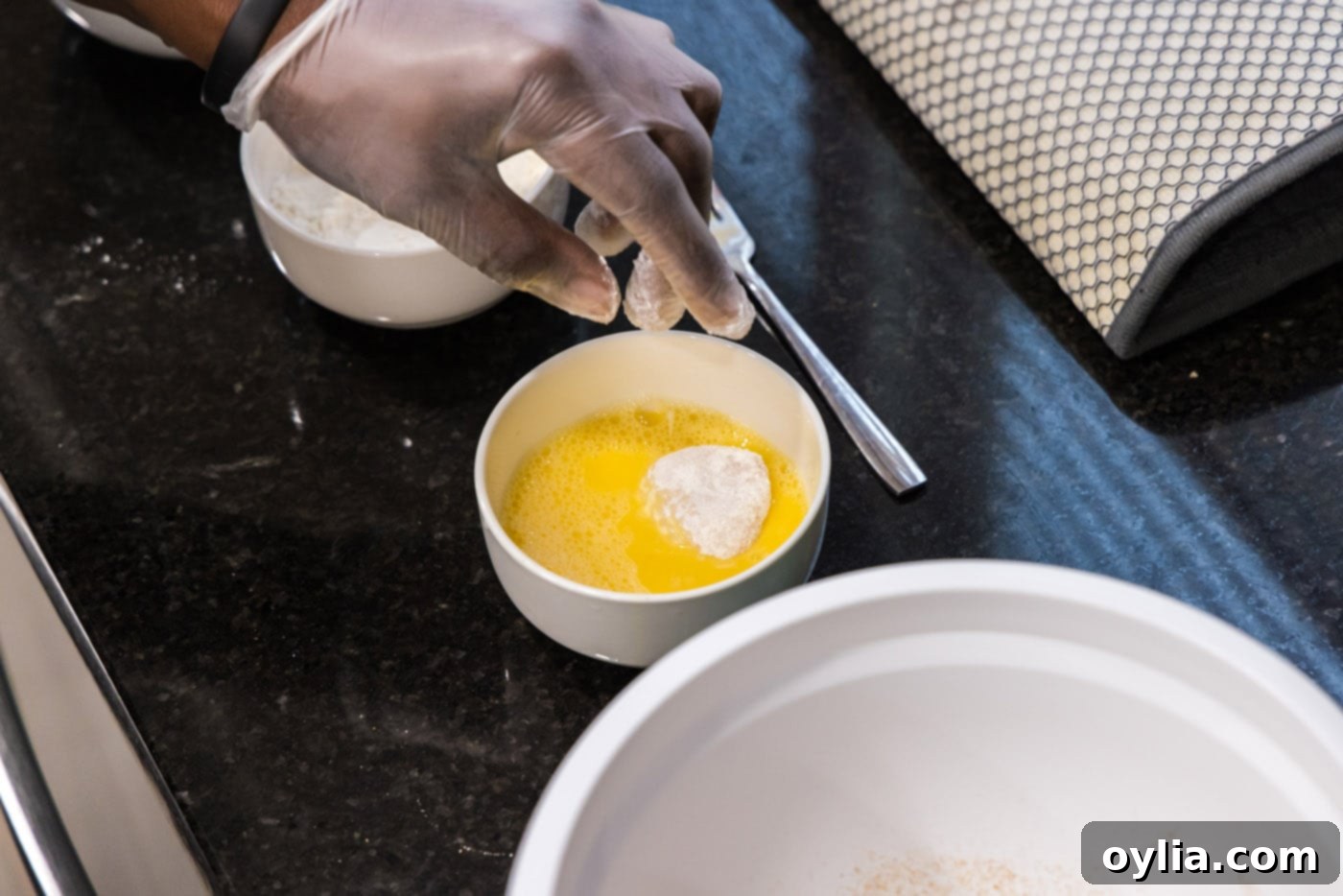 dipping floured scallop in egg
