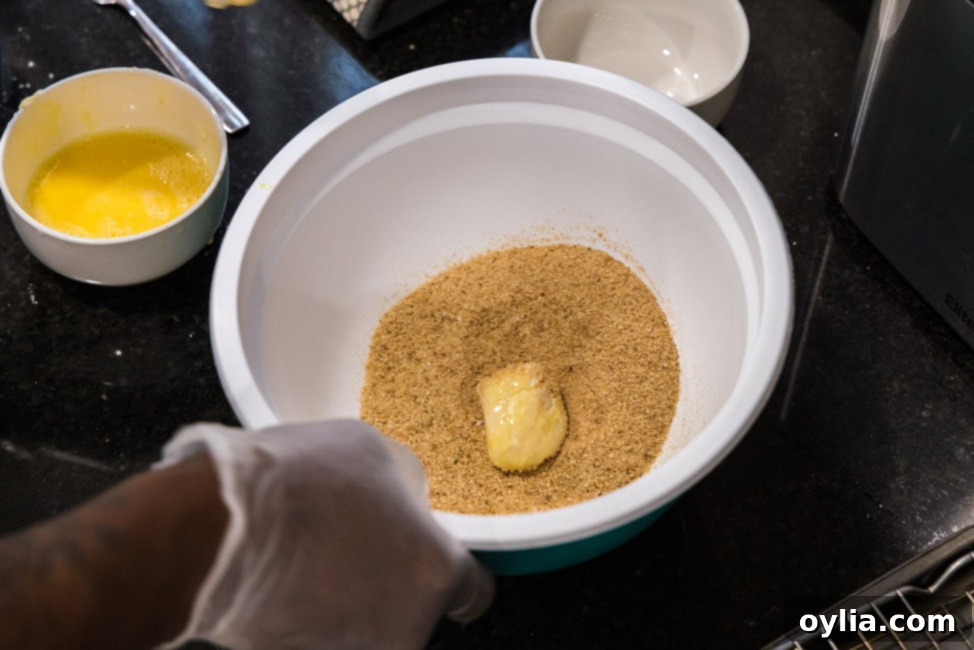 flour dredged scallop in a bowl of breadcrumbs