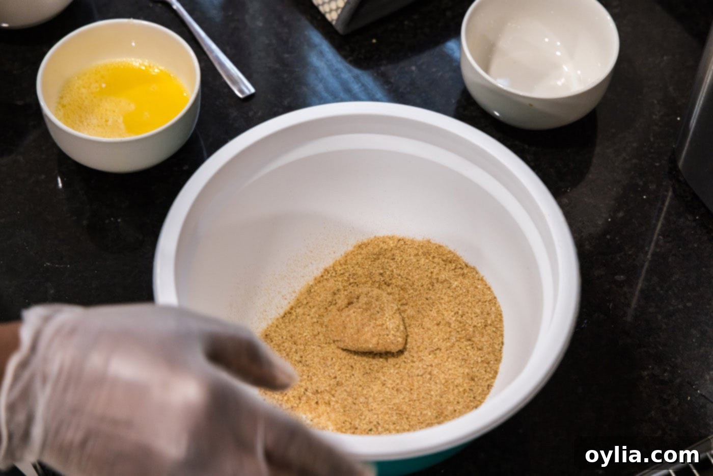 coating flour dredged scallop in breadcrumb mixture