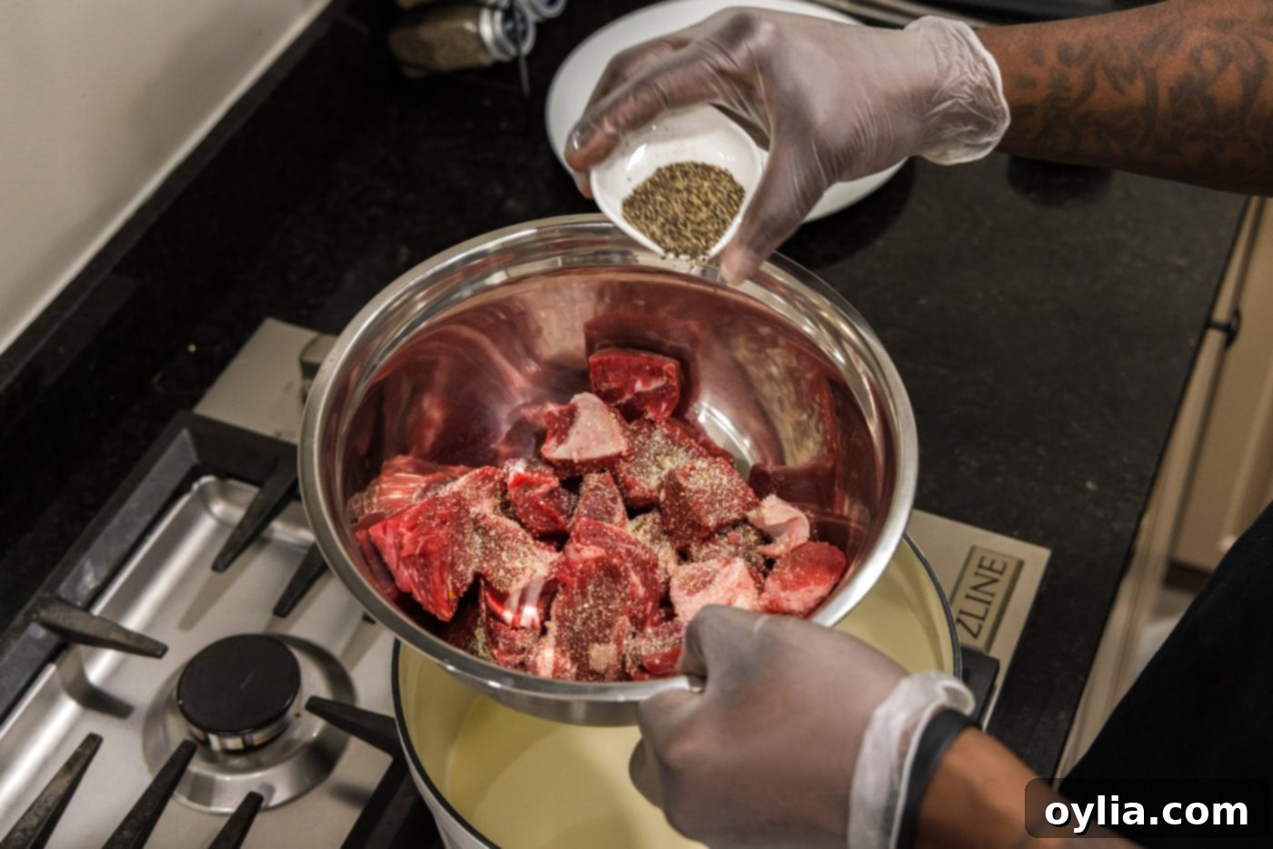 adding pepper to cubed chuck roast