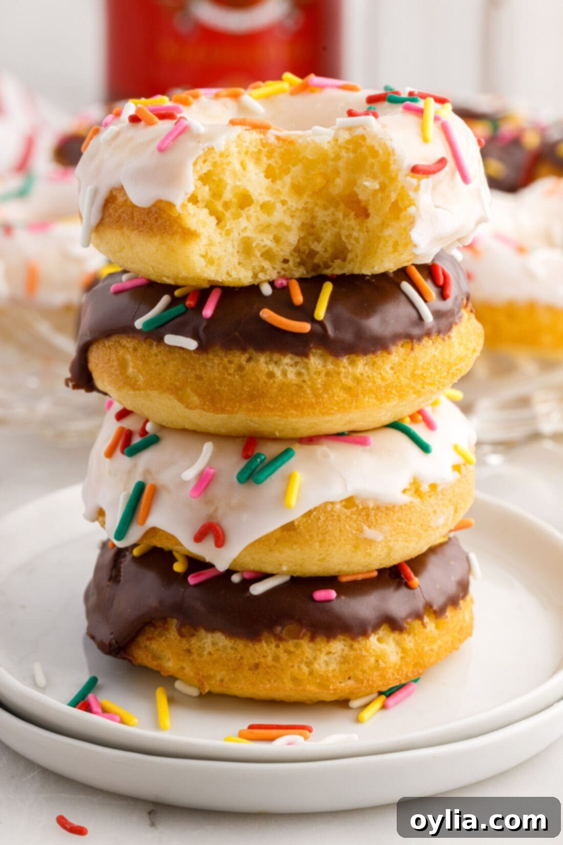 Cake Mix Donut with a bite taken out sitting on top of a stack of three Cake Mix Donuts