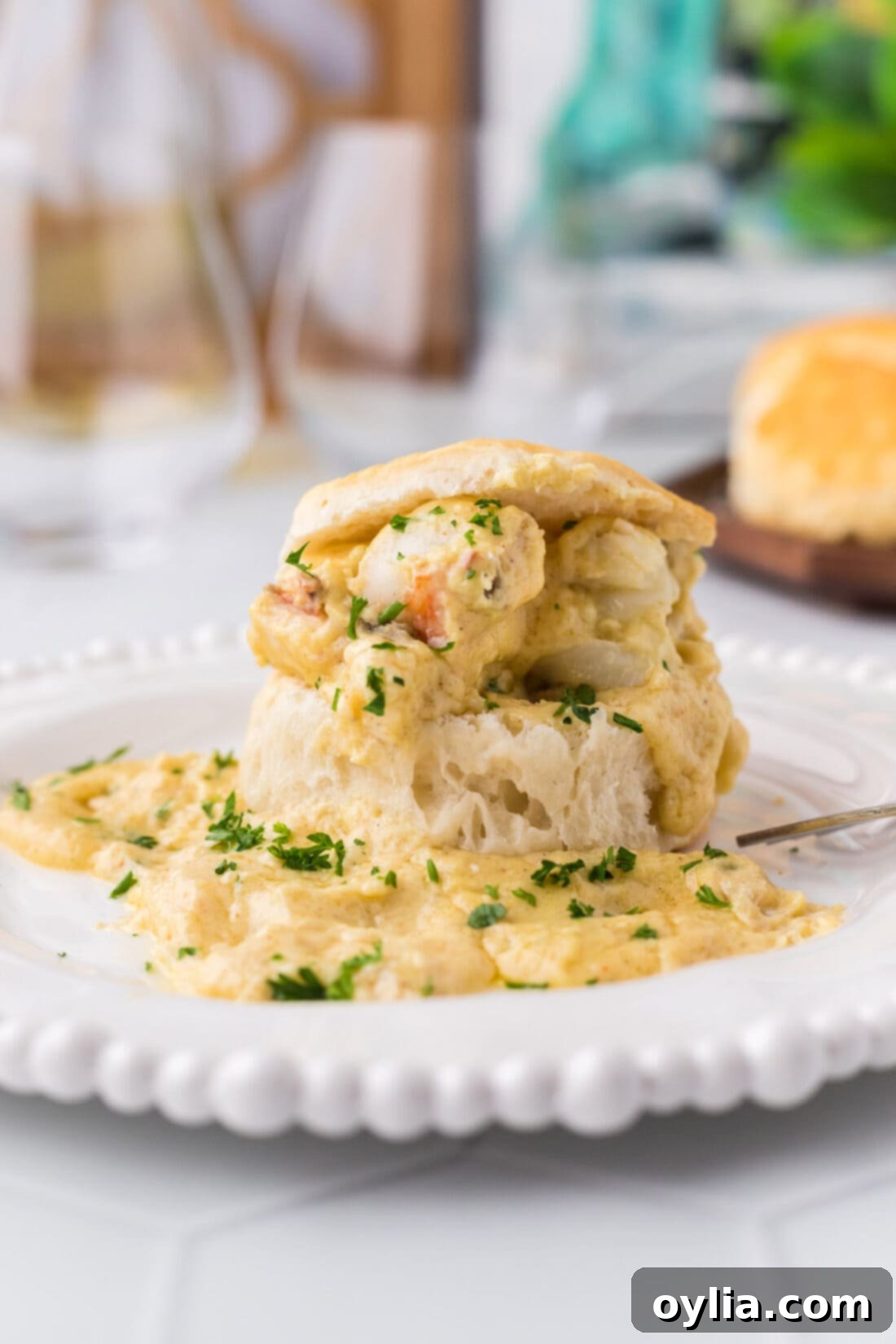 Close-up of Lobster Newburg served on an open biscuit, highlighting the creamy sauce and tender lobster.