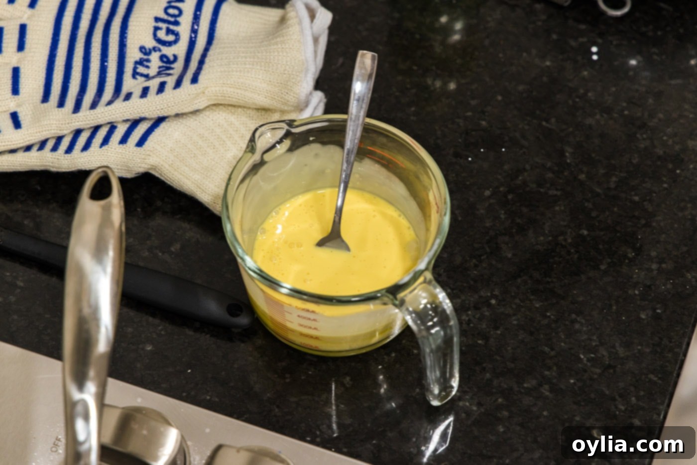 Whisked heavy cream and egg yolks in a cup, ready to be tempered into the sauce.