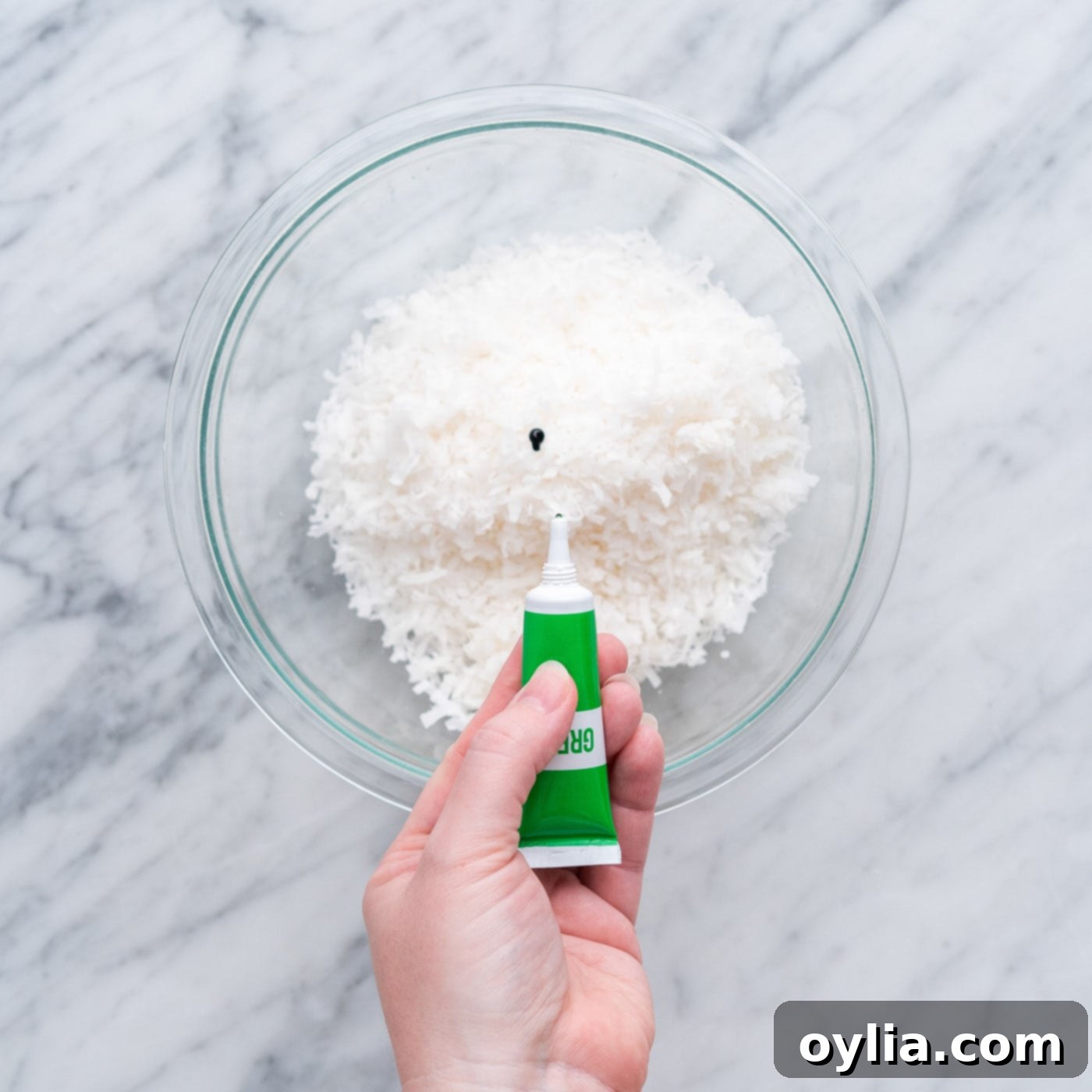 adding green gel food color to shredded coconut