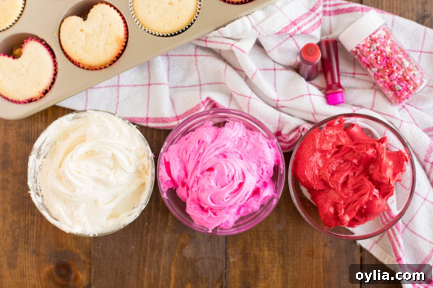 Three bowls of white, pink and red frosting