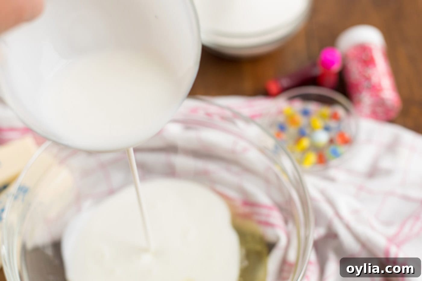 Buttermilk being poured into a bowl of egg whites