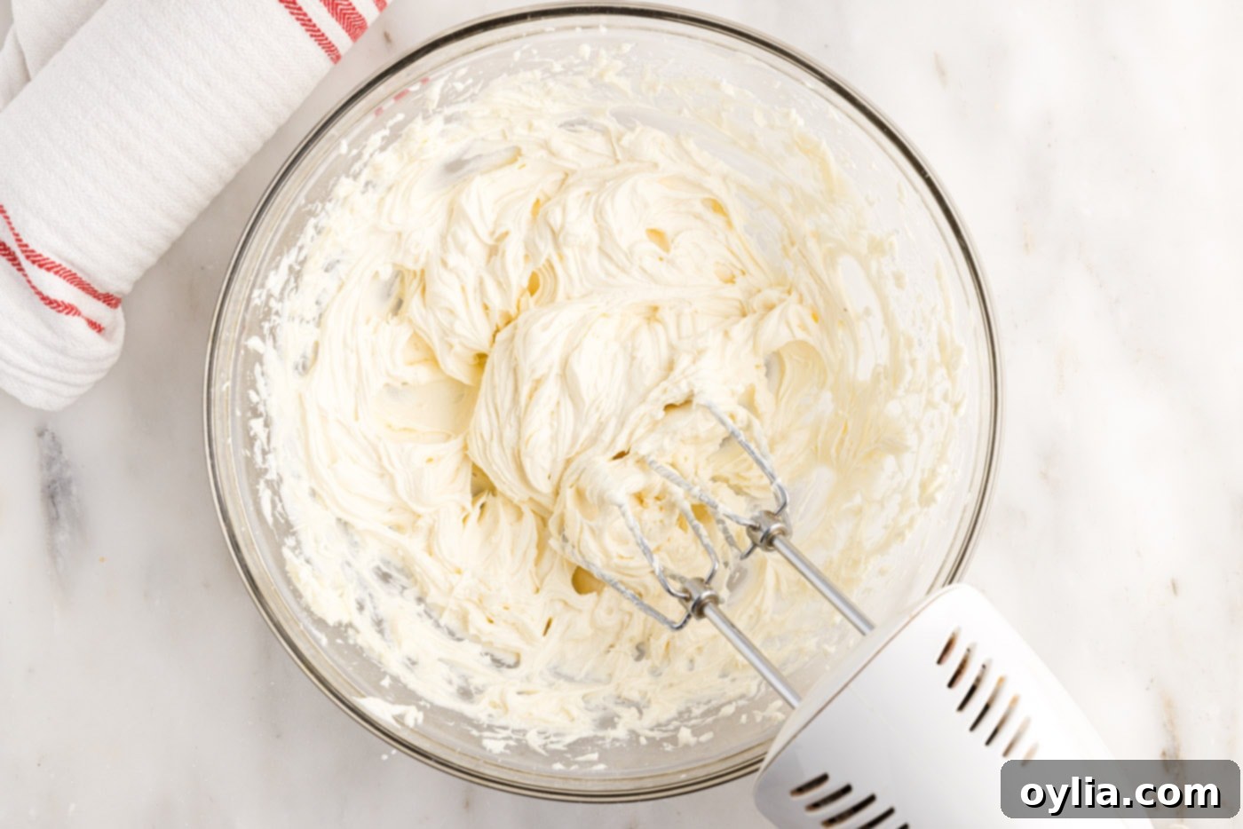 Smooth and fluffy cream cheese filling in the bowl of a stand mixer, ready to be spread