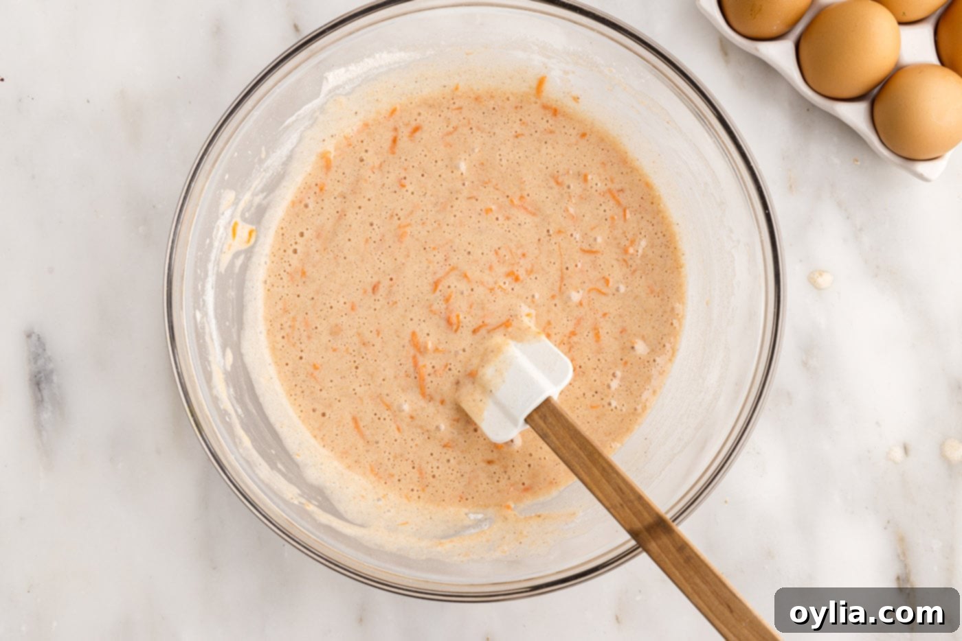 The finished carrot cake batter in a mixing bowl, ready for baking