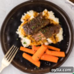 Overhead photo of Boneless Beef Short Ribs served on mashed potatoes with carrots on the side