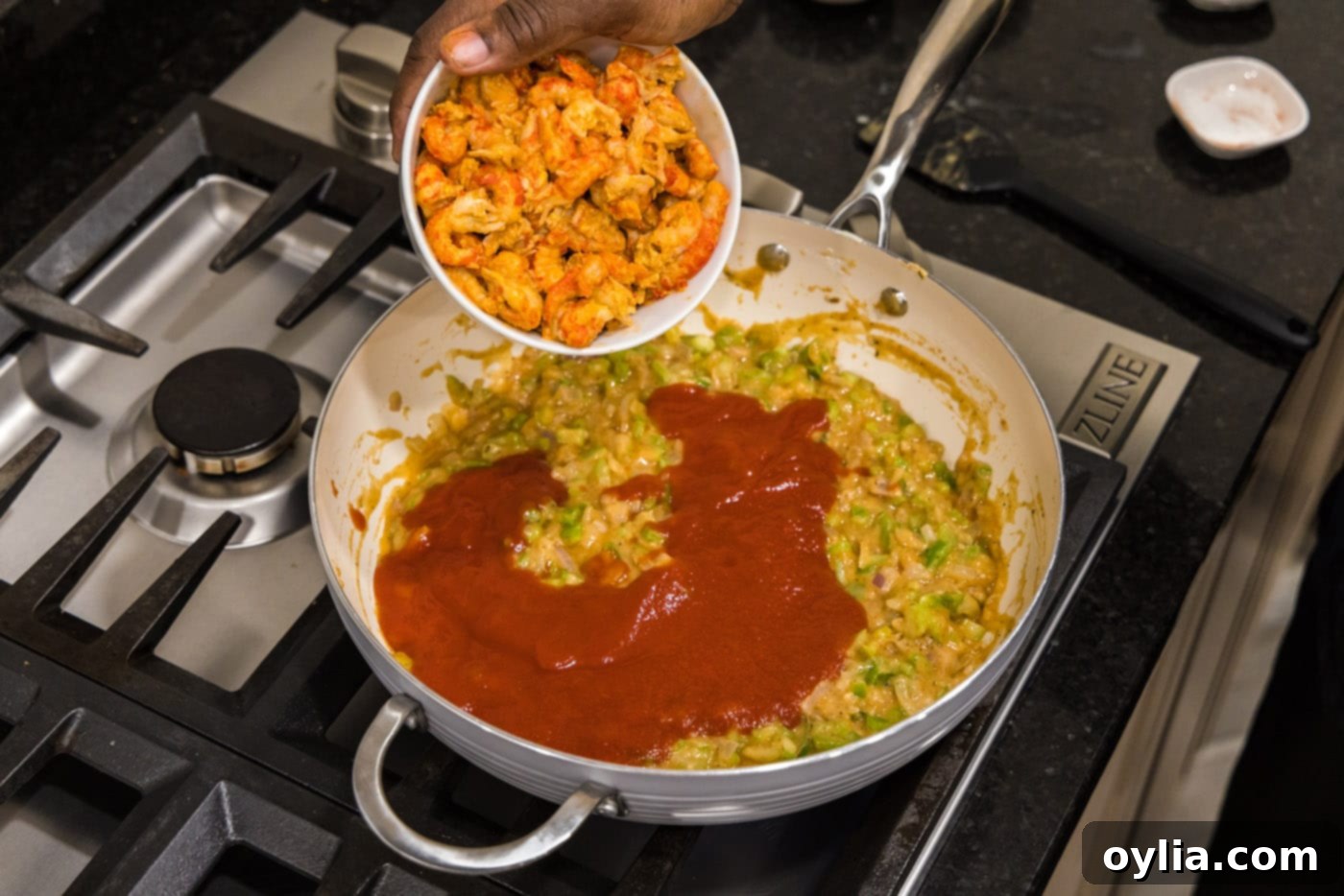 adding crawfish to skillet for crawfish etouffee, ensuring it's evenly coated in sauce