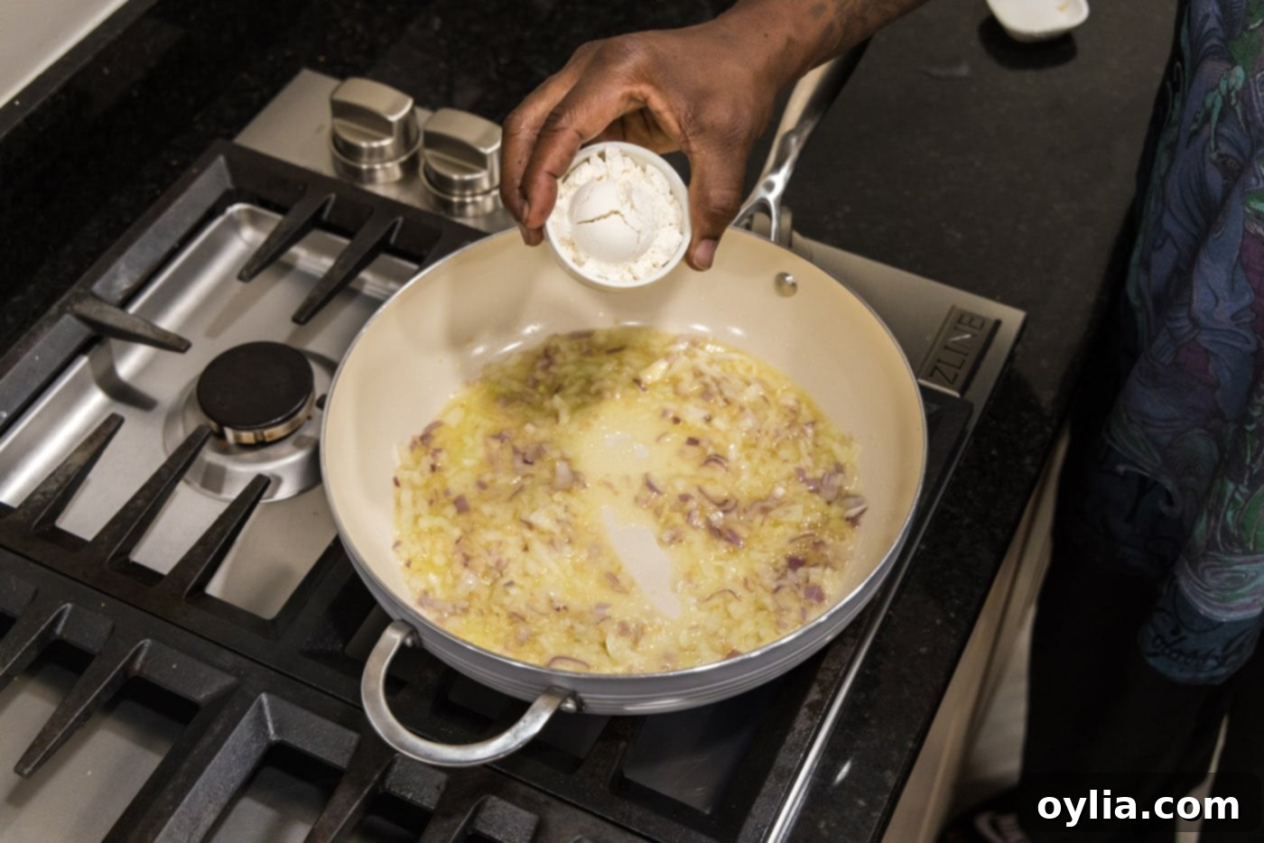 adding flour to skillet to make a roux for the etouffee base