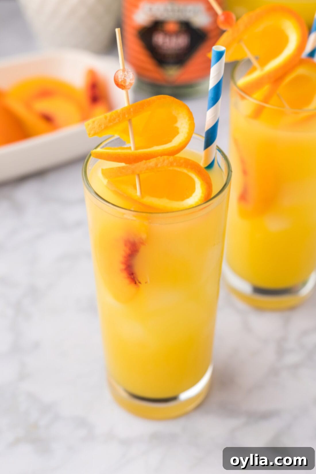 Close up photo of a Fuzzy Navel drink with ice and an orange slice.