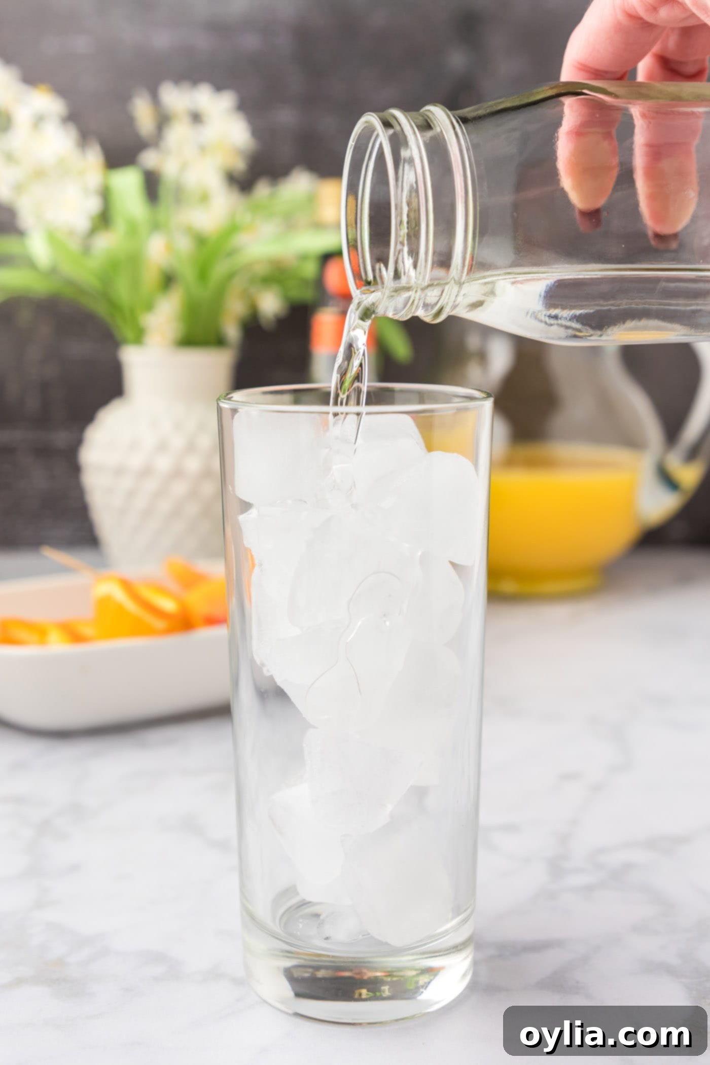pouring peach schnapps into glass of ice