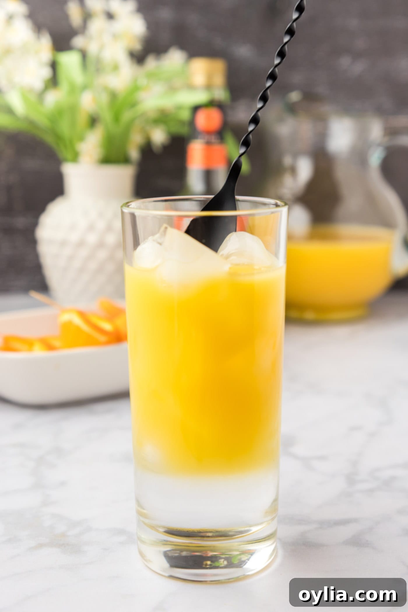 mixing fuzzy navel cocktail in a glass