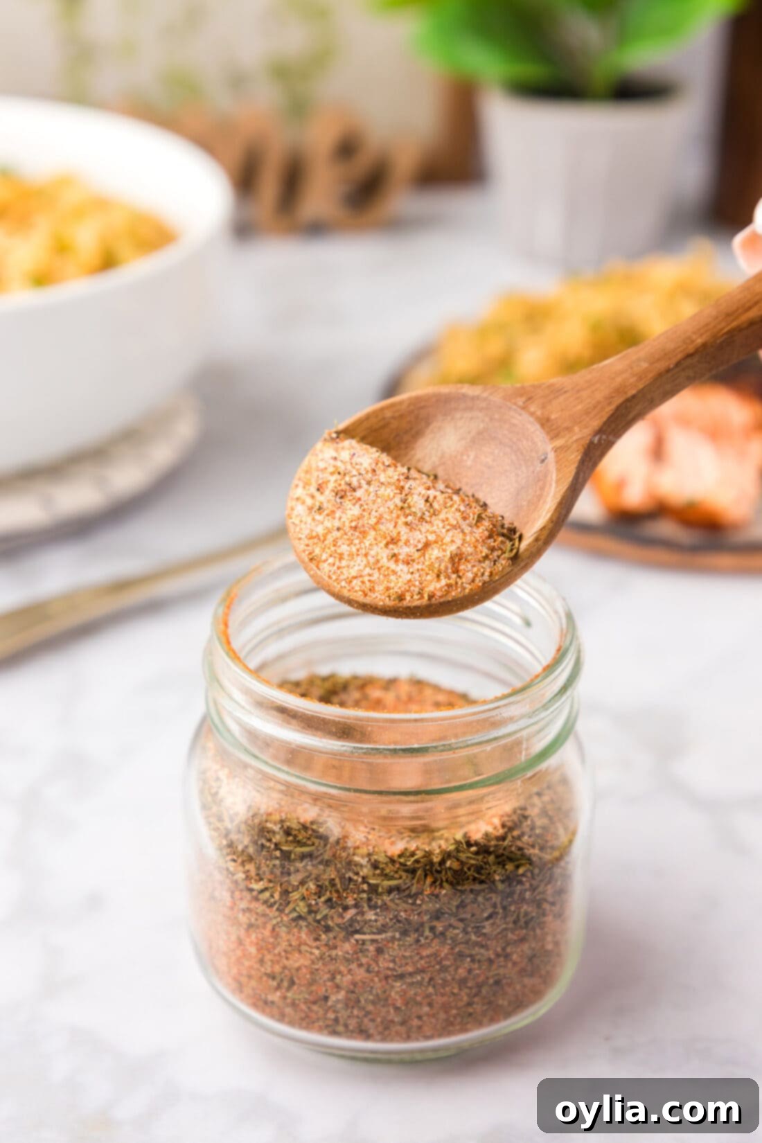 Spoonful of Cajun Seasoning being lifted out of a jar of Cajun Seasoning