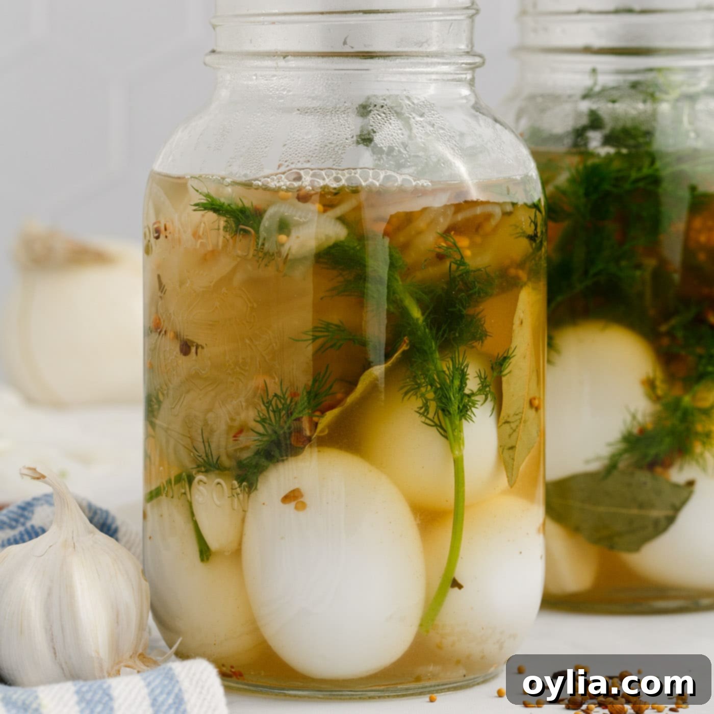 brine added to eggs with herbs in a mason jar