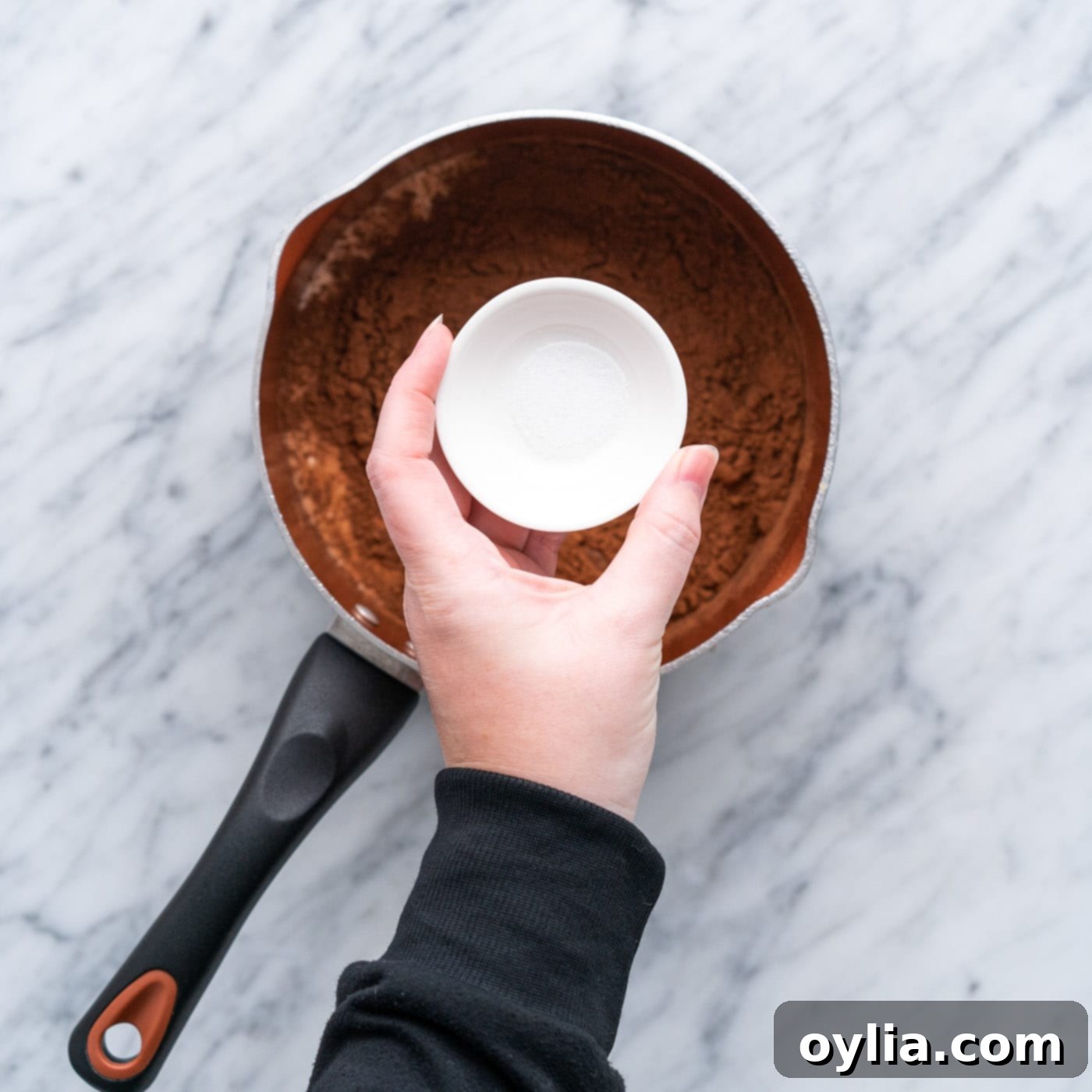 adding corn syrup to chocolate mixture in sauce pan