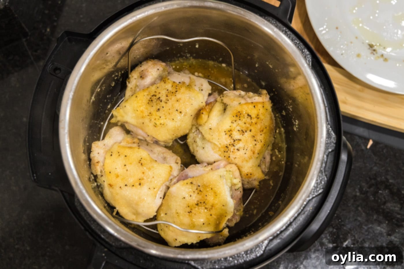 Chicken thighs carefully placed on the Instant Pot trivet, ready for pressure cooking.
