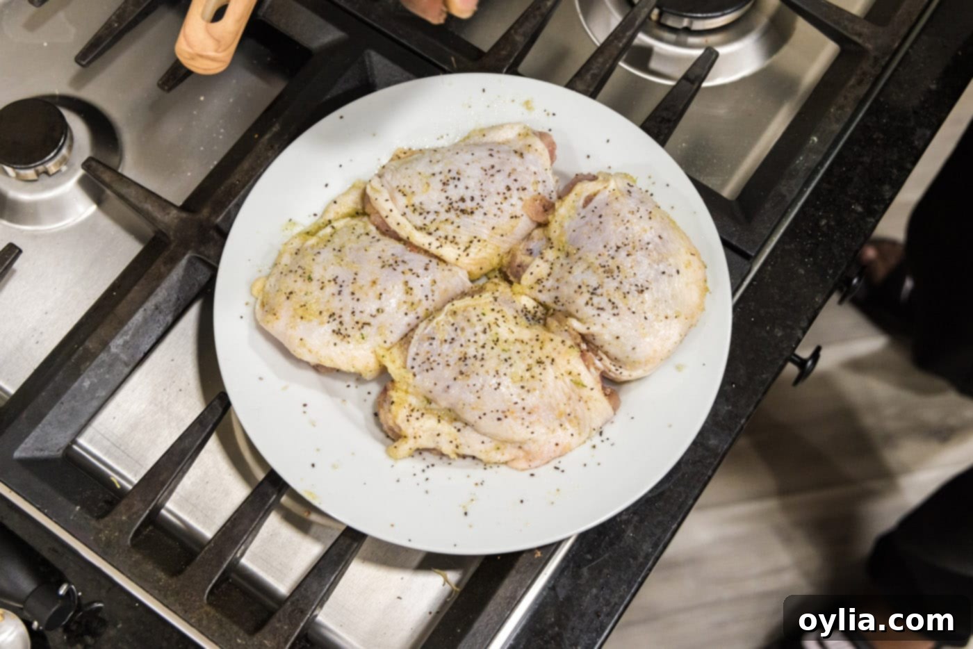 Seasoned chicken thighs on a plate, ready for searing in the Instant Pot.