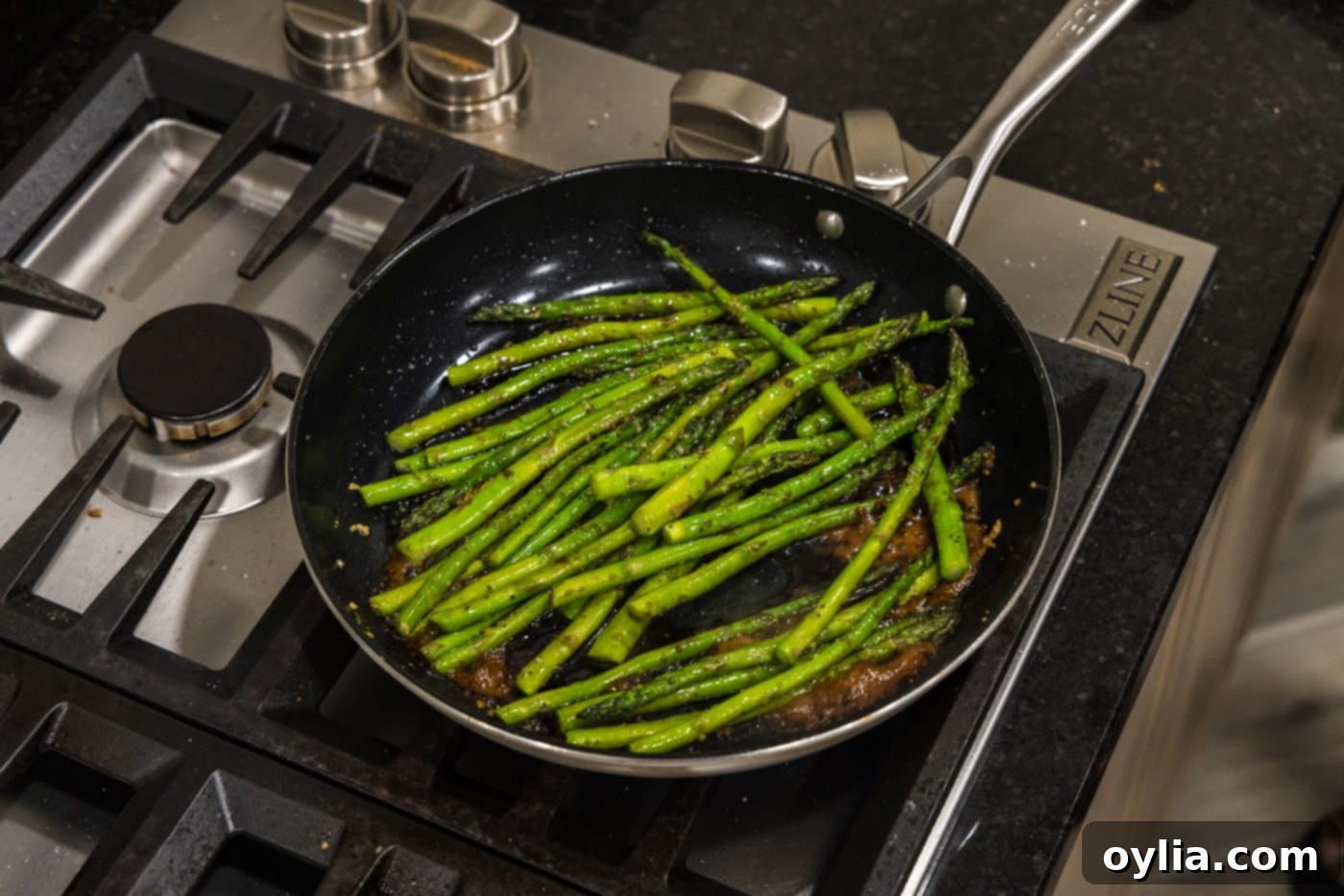 Perfectly cooked, glistening sauteed asparagus in a hot skillet, ready to be served.