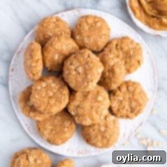 No Bake Peanut Butter Cookies on a plate with a bowl of peanut butter on the side