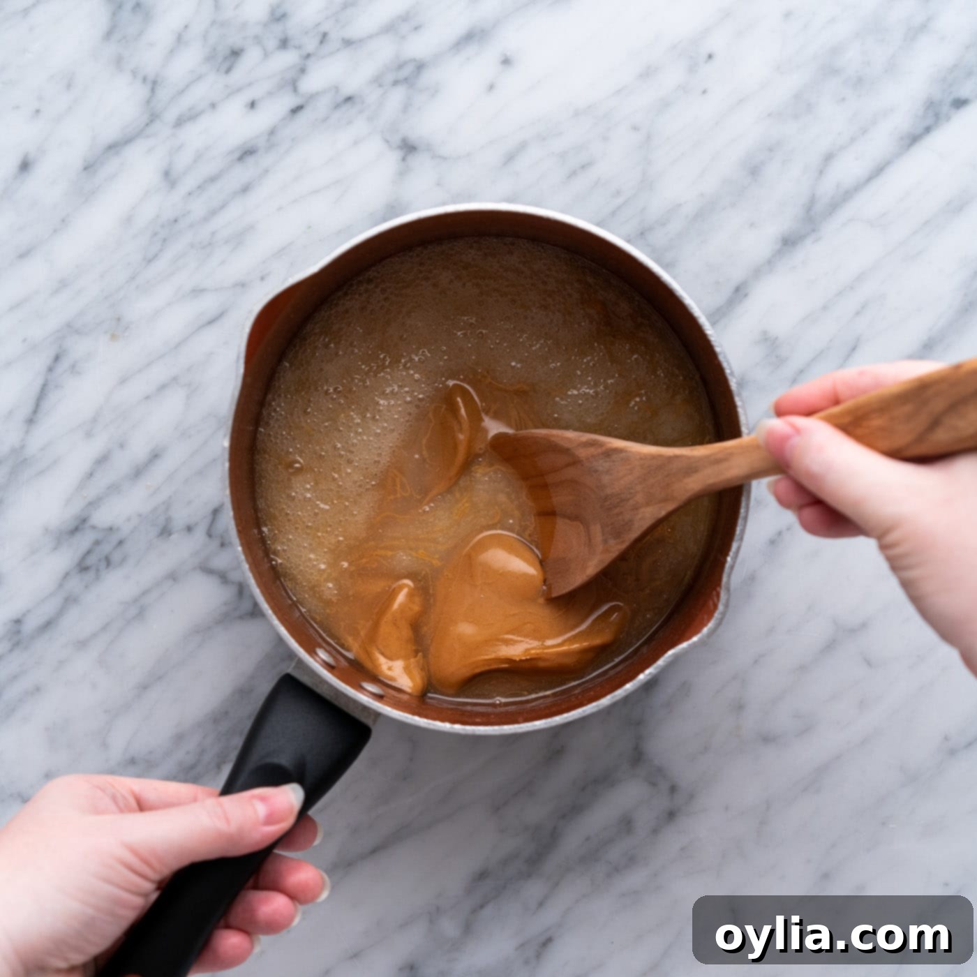 wooden spoon stirring peanut butter cookie mixture in a pan