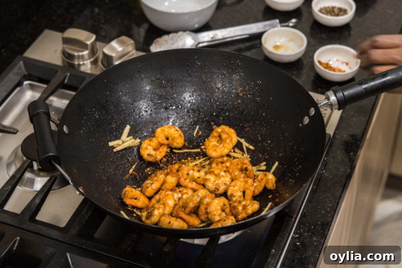 Fried shrimp added back to the wok with ginger and spices.