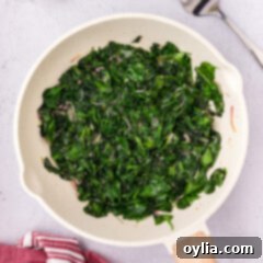Garlicky Sautéed Spinach 10 Overhead photo of Sautéed Spinach in a skillet, freshly cooked.