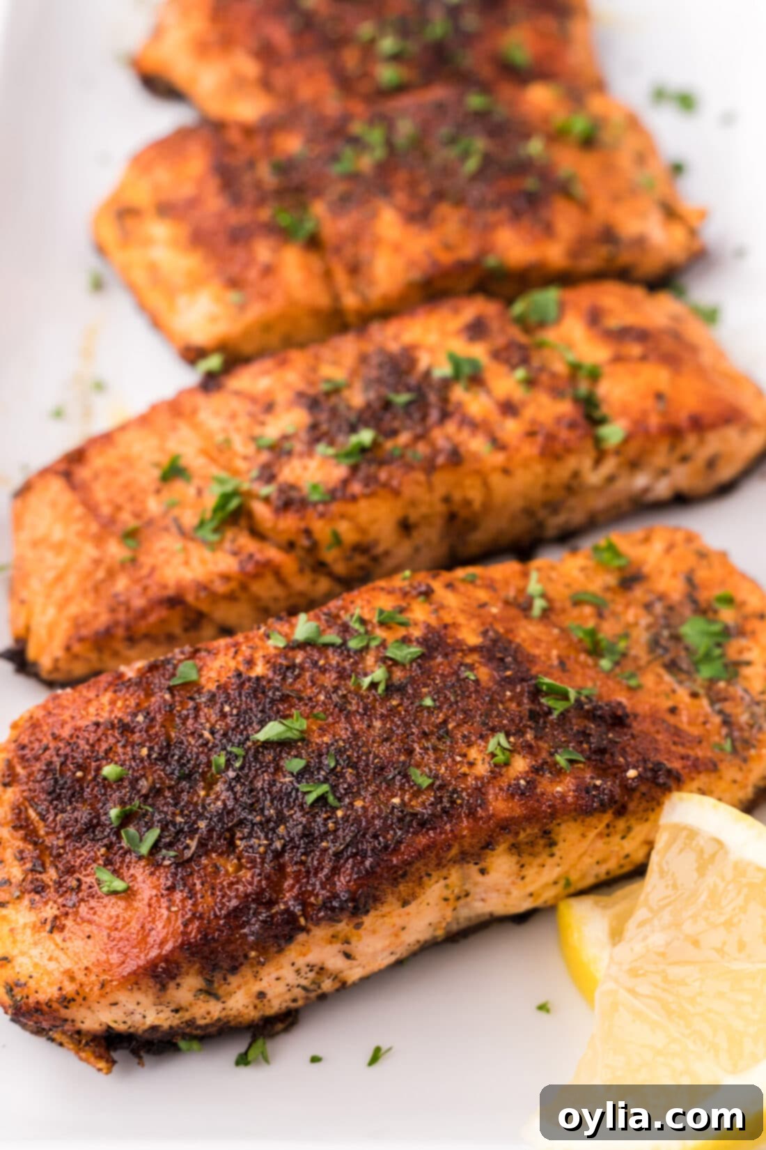 Close up photo of a platter of perfectly cooked Cajun Salmon, showing the crispy crust and vibrant seasoning
