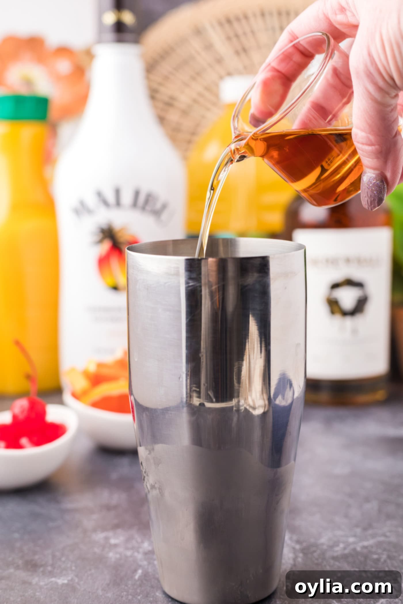 pouring peanut butter whiskey into cocktail shaker